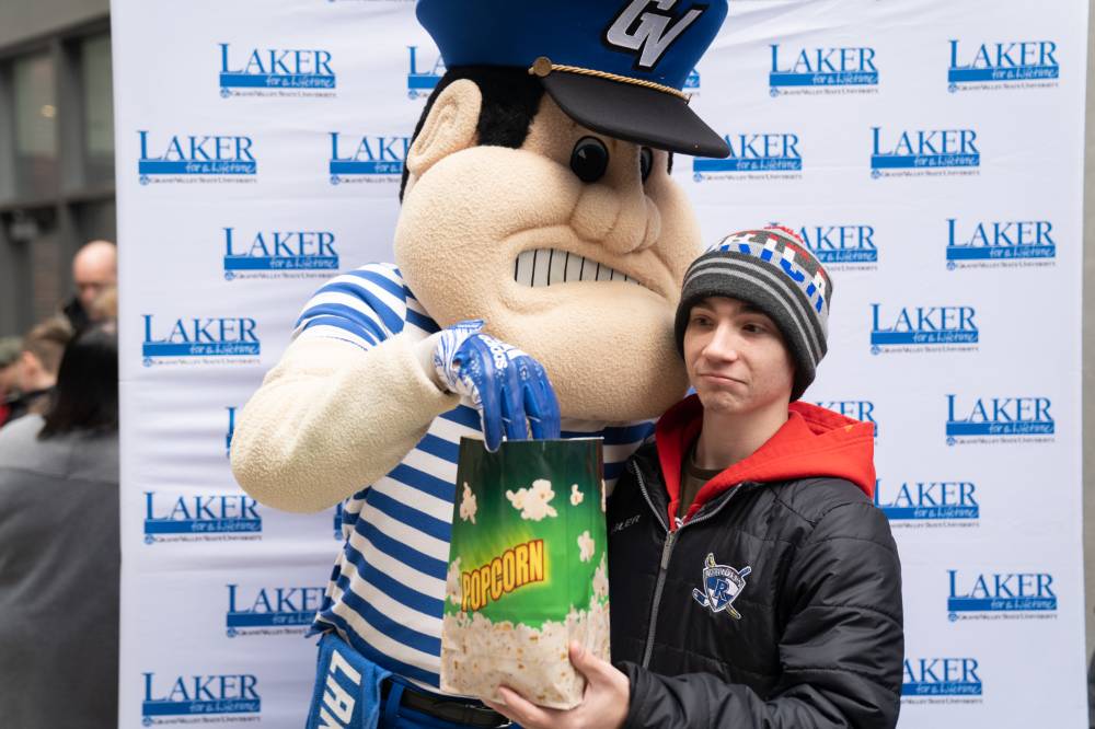 Louie the Laker shares popcorn with boy